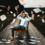 man sitting on chair with book